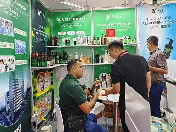 Una fábrica de gel de ducha en Guangzhou posa para una foto con clientes en una exposición.