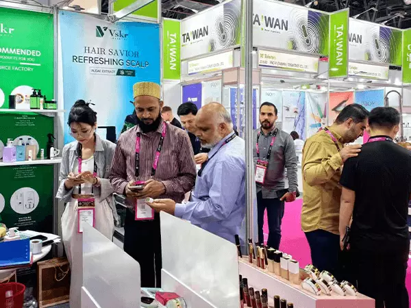 Una fábrica de gel de ducha en Guangzhou posa para una foto con clientes en una exposición.