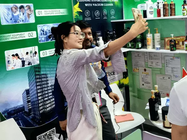 Una fábrica de gel de ducha en Guangzhou posa para una foto con clientes en una exposición.